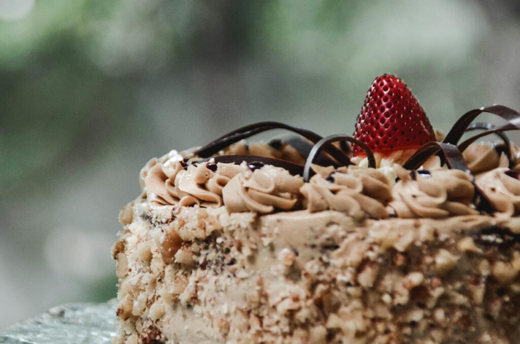 Close-up of a luxurious chocolate cake adorned with fresh strawberry and cream in Mandaue City.