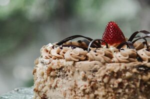 Close-up of a luxurious chocolate cake adorned with fresh strawberry and cream in Mandaue City.