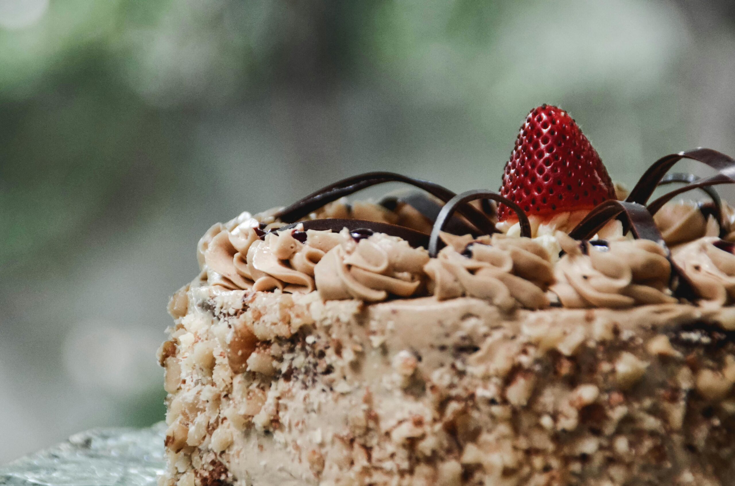 Close-up of a luxurious chocolate cake adorned with fresh strawberry and cream in Mandaue City.