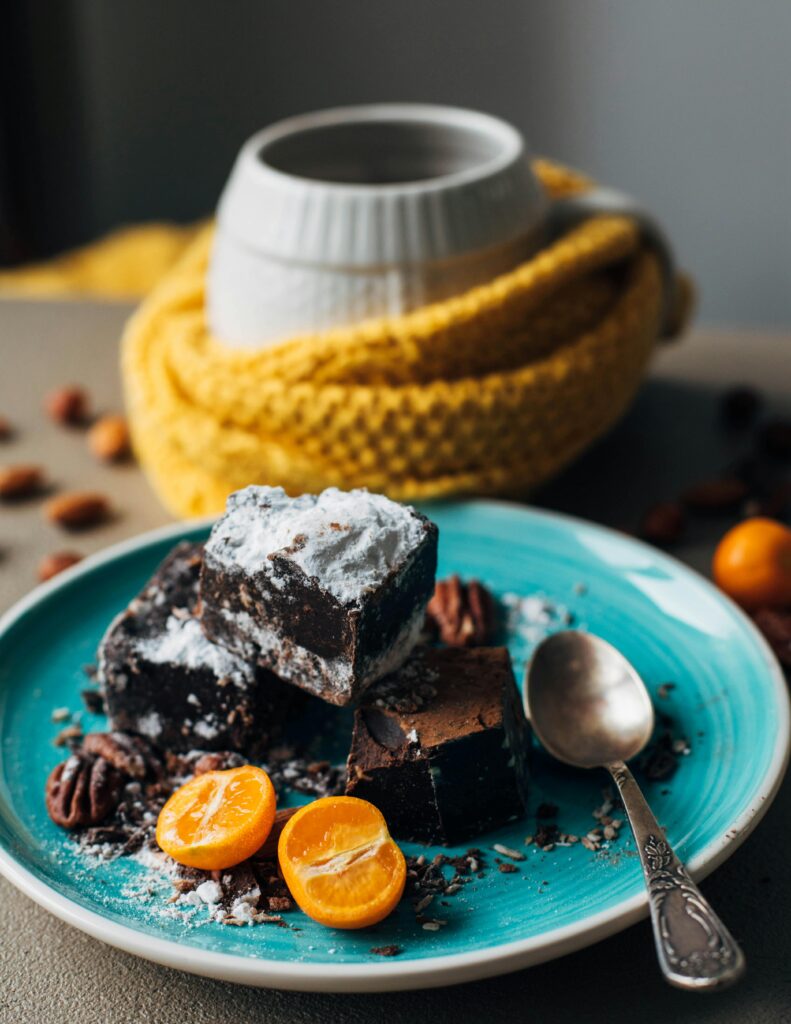 Delicious chocolate brownies dusted with sugar, served with fresh citrus and nuts.