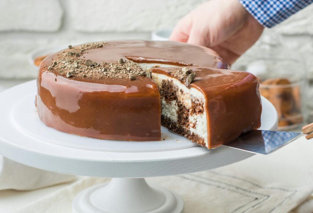 Tempting chocolate cake with creamy frosting on a cake stand, perfect for dessert lovers.