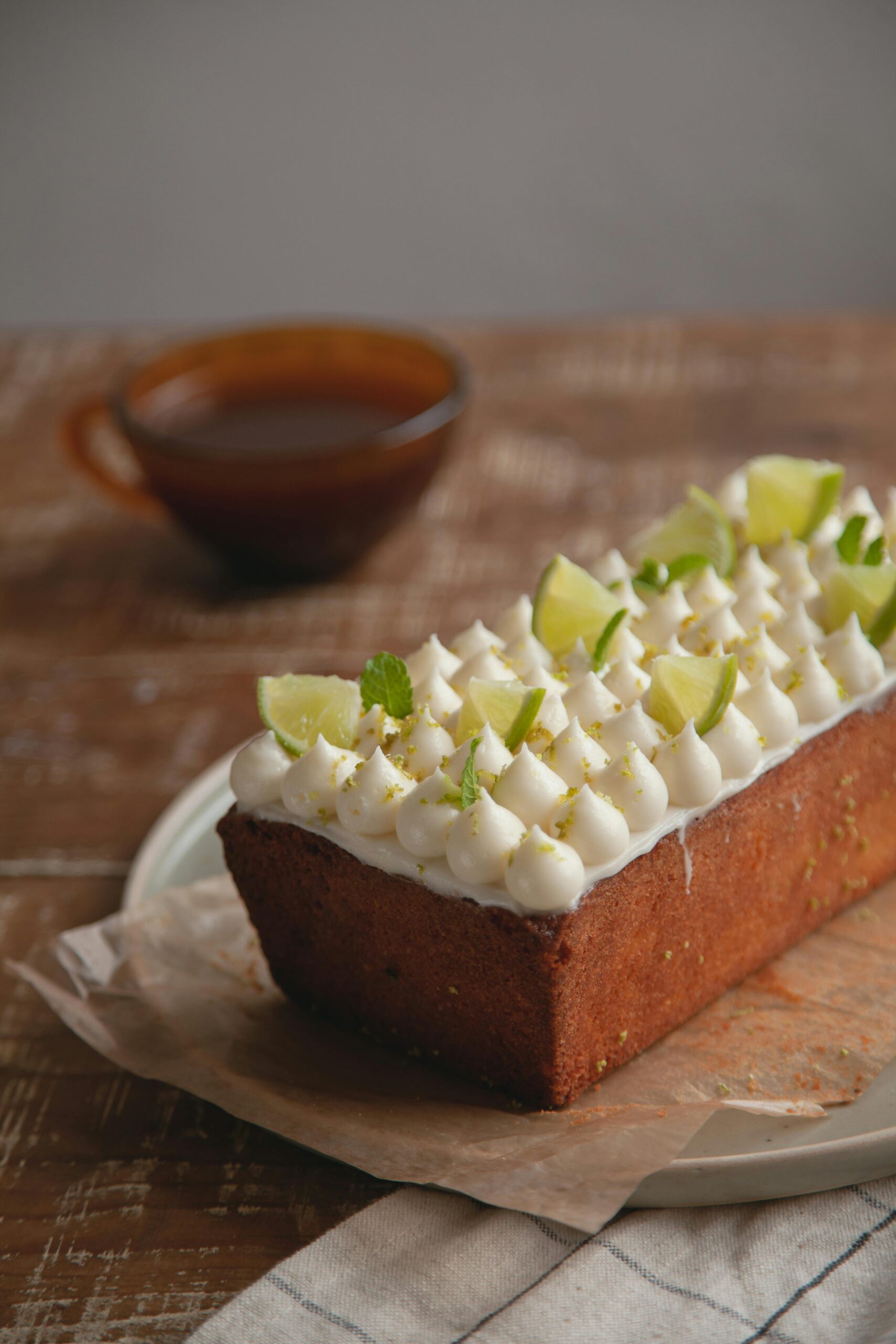 Enticing homemade lemon cake adorned with lime slices and rich frosting.